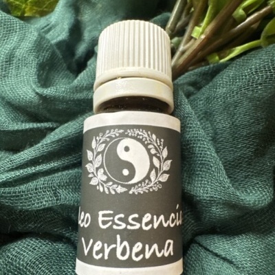 Frasco de óleo essencial de verbena com rótulo preto e branco sobre tecido verde