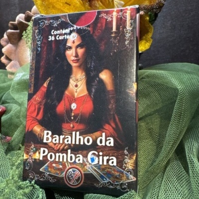 Caixa do baralho da Pomba Gira com imagem de mulher em vestido vermelho sobre tecido verde e flores amarelas ao fundo