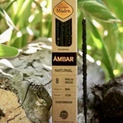 Embalagem de incenso Madre Âmbar Natural com uma vareta de incenso acesa ao lado