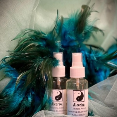 Duas garrafas de spray Alecrim com penas azuis e verdes ao fundo