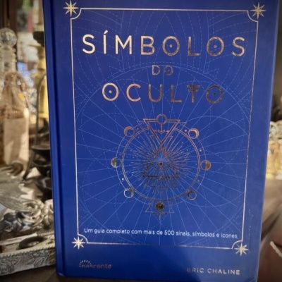 Livro Símbolos do Oculto com capa azul e texto dourado
