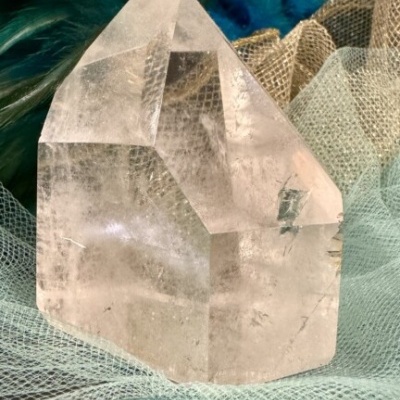 Cristal transparente sobre tecido de rede com penas coloridas ao fundo