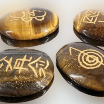 Pedras olho de tigre com símbolos dourados gravados