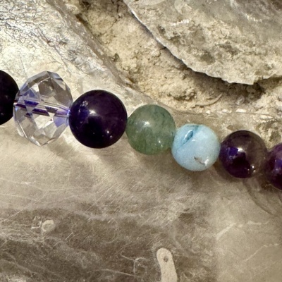 Pulseira com contas de ametista, cristal, jade e ágata sobre pedra