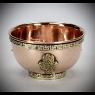 Tigela de metal cobre com detalhes dourados e símbolo Hamsá.