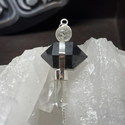 Pingente de cristais preto e transparente encostado em cristal branco