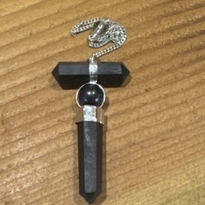 Colar com pendente em forma de cruz com pedras pretas e metal prateado