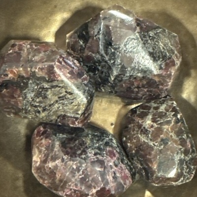 Quatro pedras polidas coloridas sobre superfície dourada