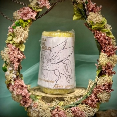 Vela amarela com rótulo de cavalo alado dentro de círculo floral decorativo