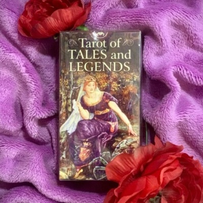 Baralho de Tarot Tarot of TALES and LEGENDS sobre tecido lilás com flores vermelhas