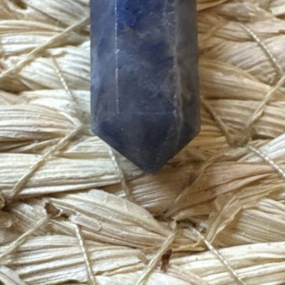Cristal azul polido em ponto sobre tecido de corda entrelaçada bege