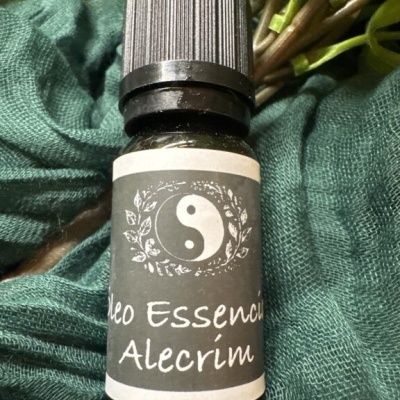 Frasco de óleo essencial de alecrim sobre tecido verde