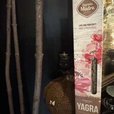 Caixa de incenso Sagrada Madre Yagra com fragrância de rosa e baunilha num ambiente rústico.