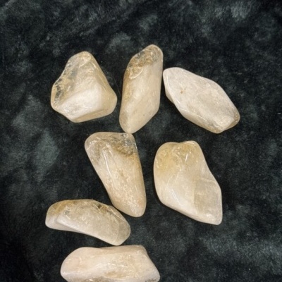 Sete pedras semipreciosas transparentes amarelas claras sobre tecido preto