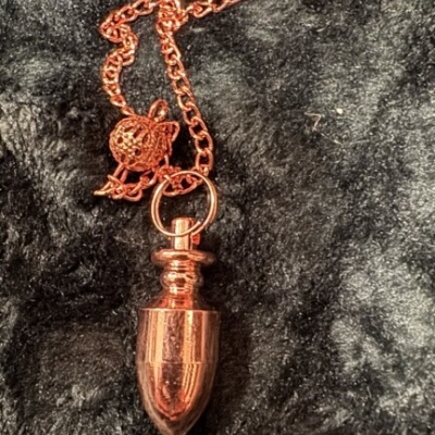 Colar com pendente cor cobre sobre tecido preto