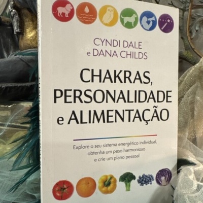 Livro Chakras, Personalidade e Alimentação com capa branca e ilustrações coloridas