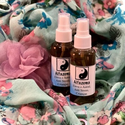 Dois frascos de spray Alfazema sobre tecido floral colorido com flor rosa