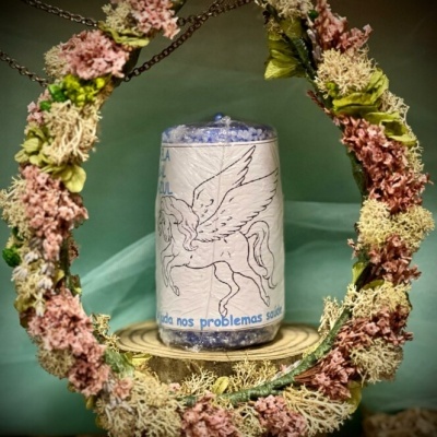 Frasco com esferas azuis e rótulo de pégaso rodeado por coroa de flores secas