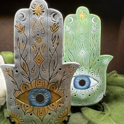 Dois pendurais Hamsa decorativos com olhos azuis e detalhes dourados e brancos