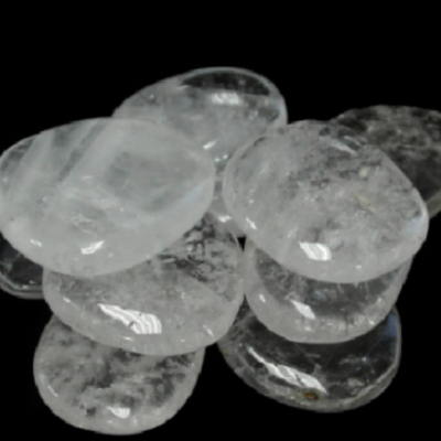 Pedras de cristal transparente polidas e ovais sobre fundo preto