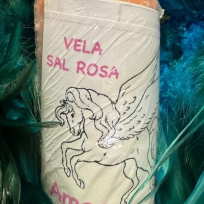 Vela de sal rosa com rótulo e ilustração de unicórnio alado em meio a penas coloridas