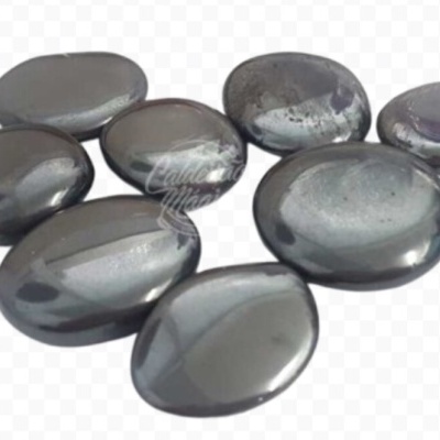 Pedras polidas de hematite metálicas em fundo branco.