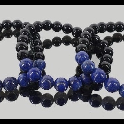 Três pulseiras de contas pretas e azuis refletidas numa superfície clara