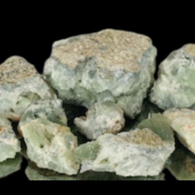 Pedaços de pedra mineral verde com manchas brancas sobre fundo preto