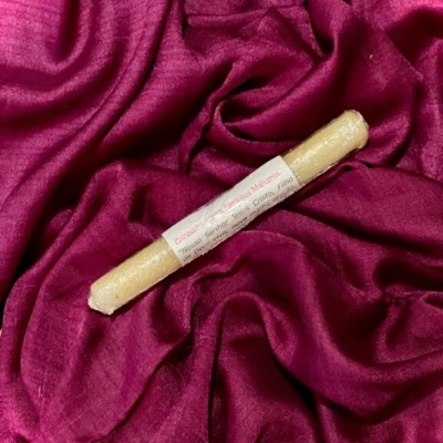 Vela fina amarela com rótulo em tecido vinho