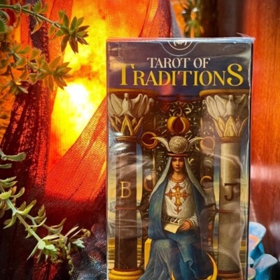 Baralho Tarot of Traditions com ilustração da Sacerdotisa em suporte azul e luz laranja ao fundo