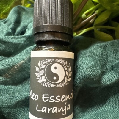 Frasco pequeno de óleo essencial de laranja com rótulo preto e branco e símbolo yin-yang