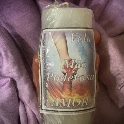 Vela embrulhada com etiqueta de mão poderosa e texto amor