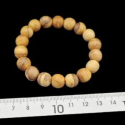 Pulseira redonda de contas de madeira com régua branca ao fundo