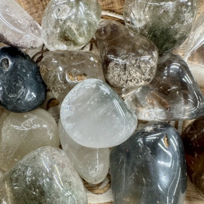 Pedras semi-preciosas polidas em várias cores sobre madeira