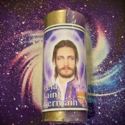 Vela Saint Germain metade dourada e roxa com rosto de homem na etiqueta