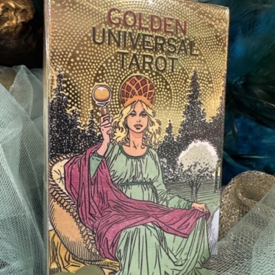 Caixa do baralho Golden Universal Tarot com mulher ilustrada em fundo dourado
