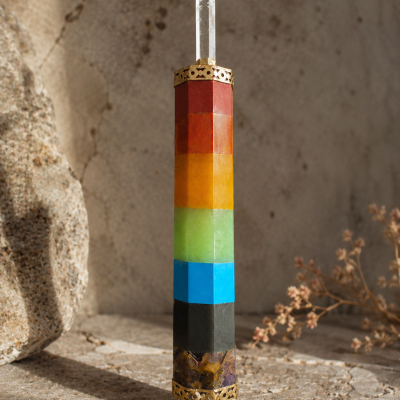 Objeto colorido hexagonal com cristal na ponta e detalhes dourados