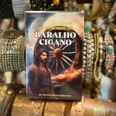 Caixa de baralho cigano com ilustração e texto em português em cima de braceletes decorativos.