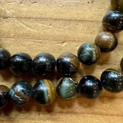 Colar ou pulseira com contas redondas multicoloridas sobre madeira