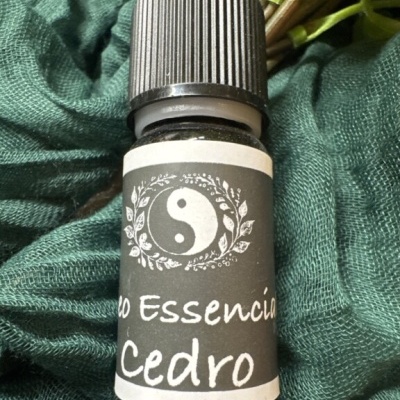 Frasco de óleo essencial Cedro com rótulo cinza e branco sobre tecido verde