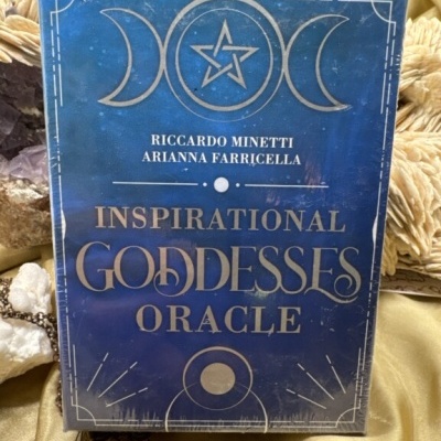 Caixa azul e dourada do baralho oráculo Inspirational Goddesses Oracle sobre tecido dourado com cristais