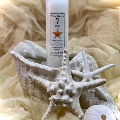 Vela votiva branca com estrelas do mar decorativas e recipiente branco texturizado