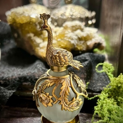 Frasco decorativo de vidro com tampa dourada em forma de pavão e ornamentos
