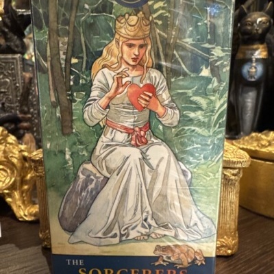 Caixa de baralho de tarot com figura sentada e texto The Sorcerers Tarot