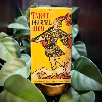 Caixa amarela de Tarot Original 1909 com figura humana e folhas verdes ao redor