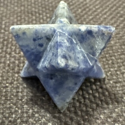 Estrela 3D de pedra azul sobre superfície cinza