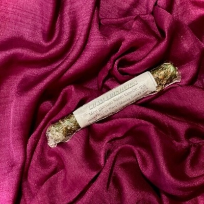 Vela artesanal com etiqueta sobre tecido de veludo vinho