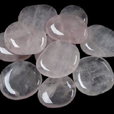 Pedras polidas de quartzo rosa em fundo preto