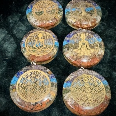 Discos redondos ornamentais com desenhos dourados e pedras coloridas em resina