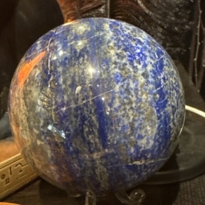 Esfera decorativa de pedra azul e branca sobre base transparente